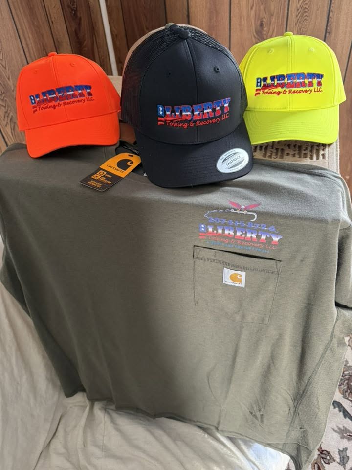 Orange, black and hi-vis Liberty hats on a green Carhartt pocket shirt