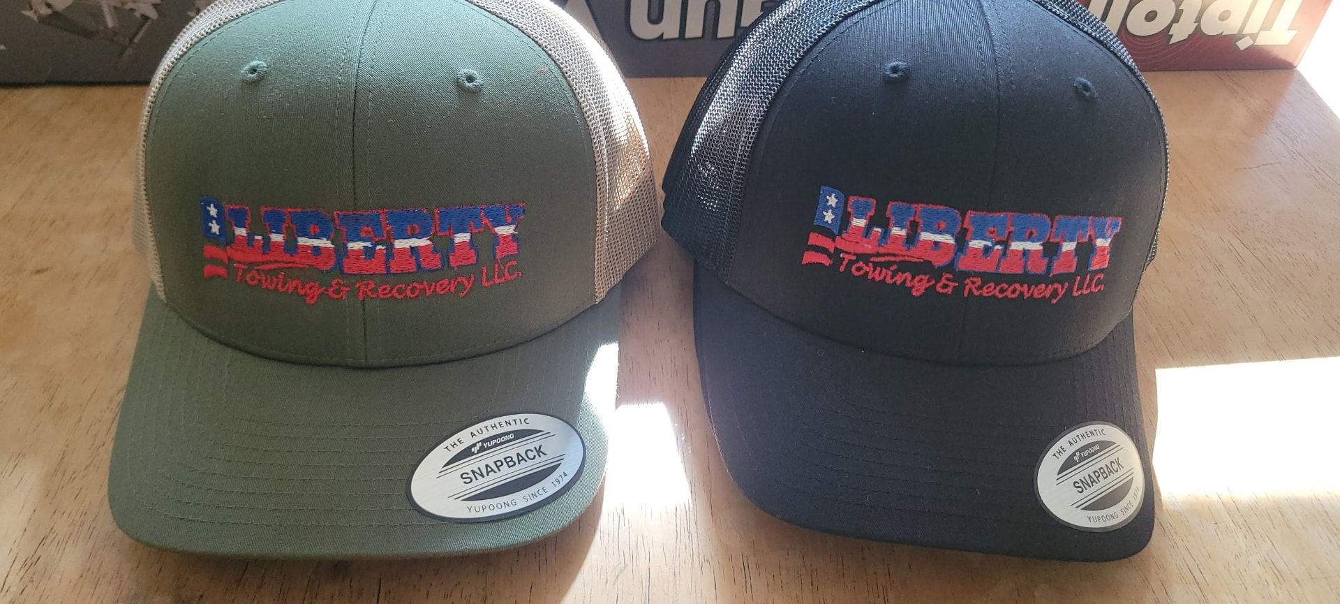 Green and navy Liberty Towing snapback trucker hats
